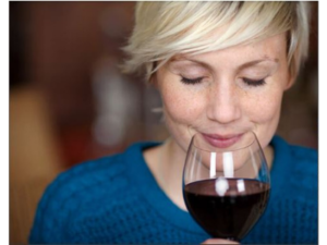 a woman enjoying the aroma of an exclusive red wine. Red wine and heart health connection.