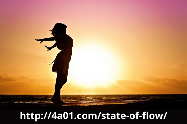 Woman's silhouette in a vibrant sunrise experiencing the State of Flow